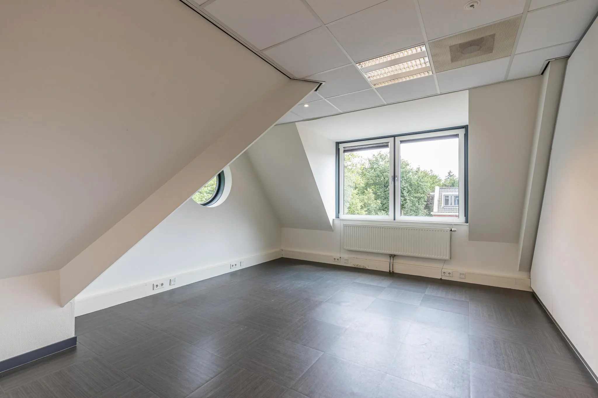 Leeg, modern kantoor met schuin plafond en ramen aan de Laan Blussé van Oud-Alblas.